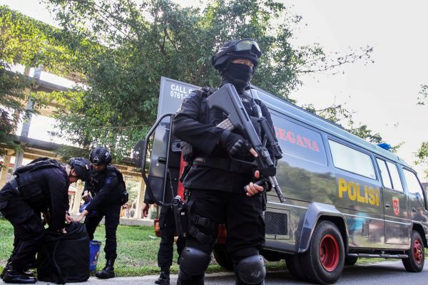 Indonesian anti-terrorism policeman holds a rifle as others seized crude bombs at Riau University building in Pekanbaru, Sumatra Island, Indonesia, 2 June 2018 (Photo: Reuters/Antara Foto/Rony Muharrman).