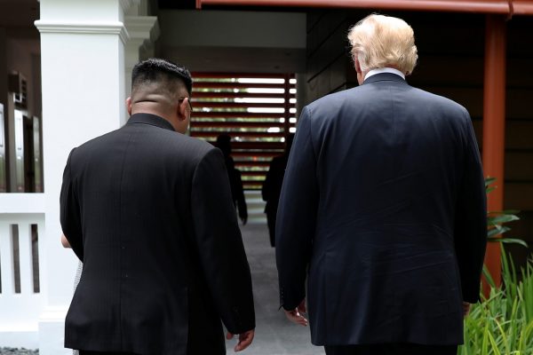 US President Donald Trump and North Korean leader Kim Jong Un walk together before their working lunch during their summit at the Capella Hotel on the resort island of Sentosa, Singapore on 12 June 2018. (Photo: Reuters/Jonathan Ernst.)