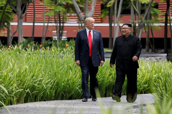 US President Donald Trump and North Korean Chairman Kim Jong-un walk together before their working lunch during their summit at the Capella Hotel on the resort island of Sentosa, Singapore, 12 June 2018 (Photo: Reuters/Jonathan Ernst).