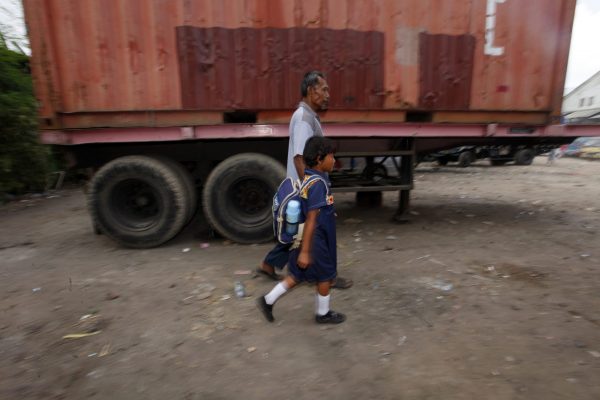 A father walks his child to school near Sekolah Darurat Kartini, Jakarta, Indonesia. (Photo: Reuters/Beawiharta).