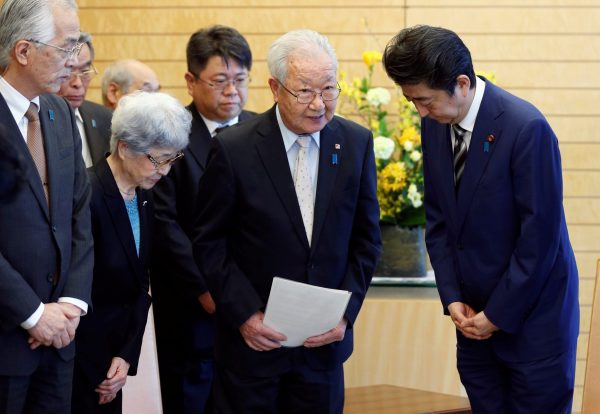 Japan's Prime Minister Shinzo Abe meets Shigeo Iizuka, the leader of a group of families of Japanese abducted by North Korea, and its members at Abe's official residence in Tokyo, Japan, 30 March 2018 (Photo: Reuters/Toru Hanai/Pool).