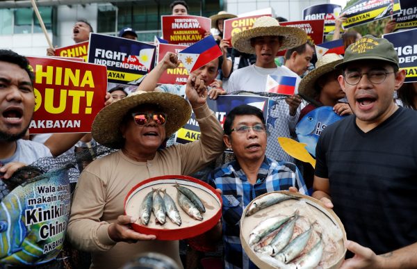 Members of Akbayan activist group display fish as they chant slogans during a rally to protest what they say is harassment of Filipino fishermen at the Scarborough Shoal in the disputed South China Sea, in Makati, Metro Manila, Philippines, 11 June 2018 (Photo: Reuters/Erik De Castro).
