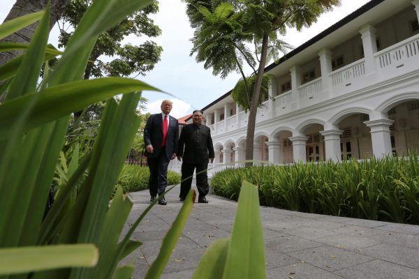 US President Donald Trump and North Korea’s leader Kim Jong-un walk together before their working lunch during their summit at the Capella Hotel on the resort island of Sentosa, Singapore, 12 June 2018. (Photo: Reuters/Jonathan Ernst).