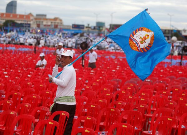A supporter of the ruling Cambodian People's Party (CPP) holds a CPP flag during an election campaign in Phnom Penh, Cambodia, 7 July 2018 (Photo: Reuters/Samrang Pring).