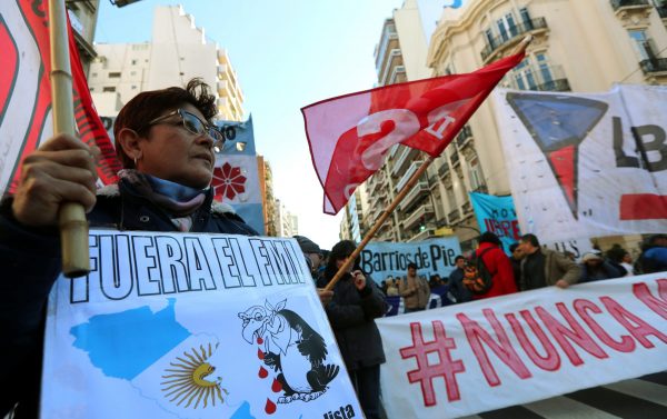 A demonstrator holds a sign that reads ‘IMF (International Monetary Fund), get out’ during a protest against the G20 Meeting of Finance Ministers in Buenos Aires, Argentina, 21 July 2018 (Photo: Reuters/Marcos Brindicci).