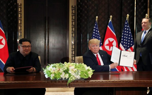 US President Donald Trump shows the document, that he and North Korea's leader Kim Jong Un signed acknowledging the progress of the talks and pledge to keep momentum going, after their summit at the Capella Hotel on Sentosa island in Singapore 12 June 2018 (Photo: Reuters/Jonathan Ernst).