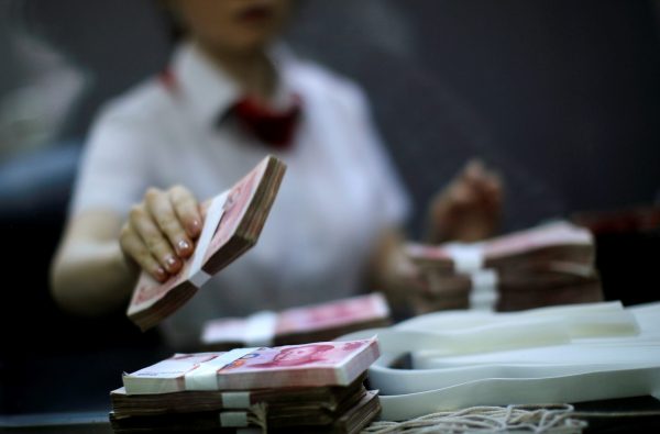 An employee of the Industrial and Commercial Bank of China Ltd counts money at one of the bank's branches at the Shanghai Free Trade Zone in Pudong district, in Shanghai, 24 September 2014 (Photo: Reuters/Carlos Barria).