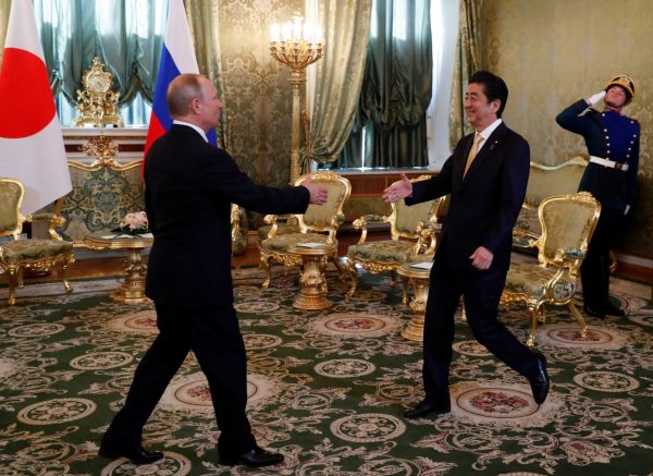 Russian President Vladimir Putin welcomes Japanese Prime Minister Shinzo Abe during their meeting at the Kremlin in Moscow, Russia, 26 May 2018 (Photo: Reuters/Grigory Dukor).