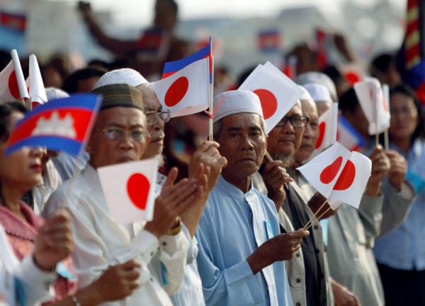 People hold Cambodian and Japanese flags during the inauguration ceremony of the road N.1 build with Japan aid in Phnom Penh, Cambodia, 13 March 2018 (Photo: Reuters/Samrang Pring).