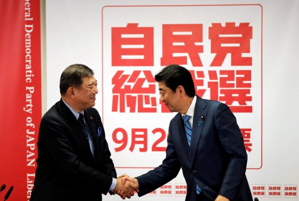 Japan's Prime Minister and ruling Liberal Democratic Party (LDP) leader Shinzo Abe and ex-defence minister Shigeru Ishiba shake hands at the end of their joint news conference for the LDP party leader election at the party's headquarters in Tokyo, Japan, 10 September 2018 (Photo: Reuters/Toru Hanai).