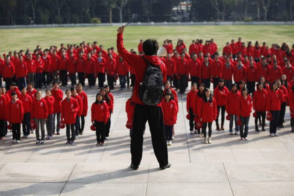 A Fudan University student member of the Chinese Communist Party directs his school mates as they stand in formation to create the party's emblem to mark the 18th National Congress of the Communist Party of China in Shanghai, 6 November 2012 (Photo: Reuters/Aly Song).