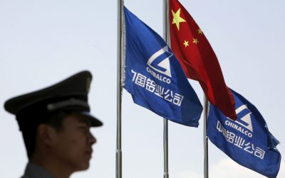 A security guard stands in position in front of the company's and Chinese flags outside the headquarters of Aluminum Corp of China in Beijing, 5 June 2009 (Photo: Reuters/Christina Hu).