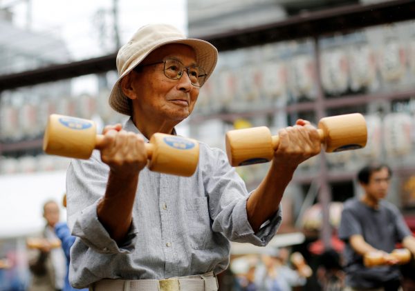 Elderly and middle-aged people exercise with wooden dumbbells during a health promotion event to mark Japan's 'Respect for the Aged Day' at a temple in Tokyo's Sugamo district, an area popular among the Japanese elderly, Japan, 19 September 2016 (Photo: Reuters/Toru Hanai).