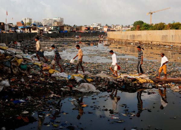 Residents cross a polluted water canal at a slum on the World Environment Day in Mumbai, India, 5 June 2017 (Photo: Danish Siddiqui/Reuters).