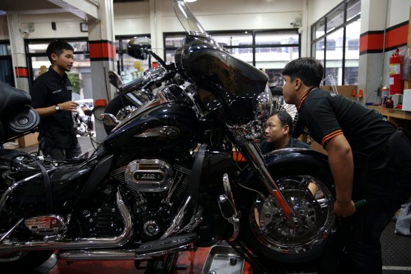 Workers work near a Harley Davidson motorcycle at a garage in Bangkok, Thailand, 28 June 2018 (Photo: Reuters/Athit Perawongmetha).