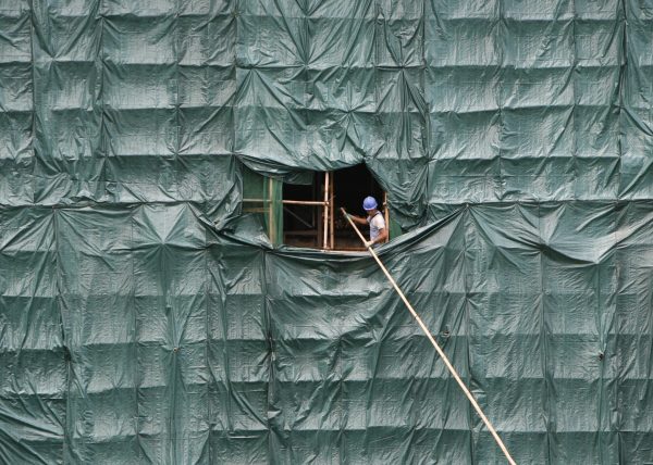 A worker disassembles bamboo scaffolding in the Central district of Hong Kong (Photo: Reuters/Victor Fraile).