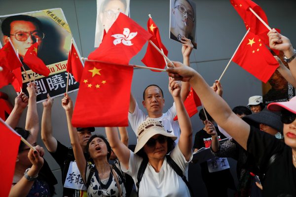 Pro-China protesters raise their flags right in front of pro-democracy protesters holding posters as two groups face in central Hong Kong, China, as the city marks the 20th anniversary of the city's handover from British to Chinese rule, 30 June 2017 (Photo: Reuters/Damir Sagolj).
