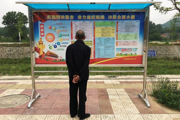 A man looks at a local government notice board in the settlement of Dajing in rural Shaanxi province, China, 11 June 2017 (Photo: Reuters/Sue-Lin Wong).