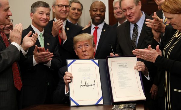 US President Donald Trump receives applause after signing S. 2155 – Economic Growth, Regulatory Relief, and Consumer Protection Act, at the White House in Washington DC, United States, 24 May 2018 (Photo: Reuters/Kevin Lamarque).