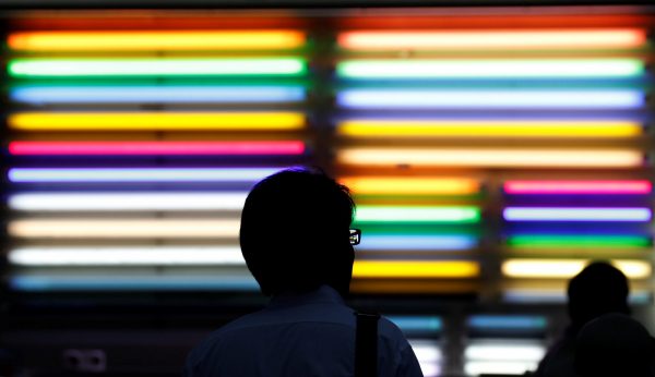 A pedestrian passes by fluorescent light tubes displayed outside a light bulb store in Tokyo's Akihabara district, Japan, 10 August 2017 (Photo: Reuters/Toru Hanai).