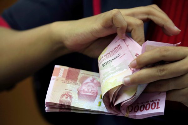 An employee counts Indonesian rupiah banknotes at a currency exchange office in Jakarta, Indonesia 23 October 2018 (Photo: Reuters/Beawiharta).