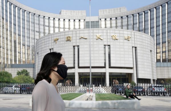 A woman walks past the headquarters of the People's Bank of China (PBOC), the central bank, in Beijing, China, 28 September 2018 (Photo: Reuters/Jason Lee).