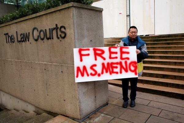 A man holds a sign outside of the BC Supreme Court bail hearing of Huawei CFO Meng Wanzhou, who is being held on an extradition warrant in Vancouver, British Columbia, Canada, 10 December 2018 (Photo: Reuters/David Ryder).