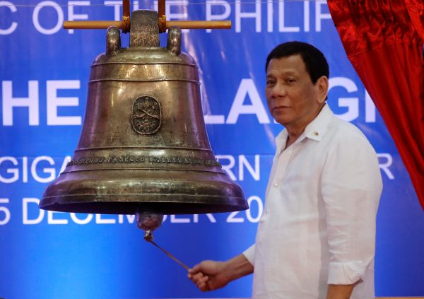 President Rodrigo Duterte rings a Balangiga bell during a ceremony marking the return of three Balangiga bells taken by the US military as war booty 117 years ago, at Balangiga, Eastern Samar in central Philippines 15 December 2018 (Photo: Reuters/Erik De Castro).