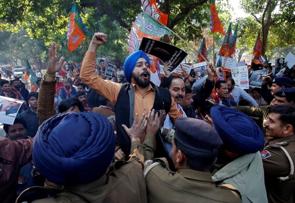 A supporter of India's ruling Bharatiya Janata Party (BJP) shouts slogans as he is stopped by police during a protest against what they call 'disinformation' by India's main opposition Congress party on a deal to buy Rafale fighter planes from a French company, in Chandigarh, India, 19 December 2018 (Photo: Reuters/Ajay Verma).