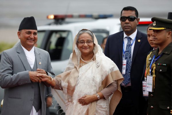 Bangladesh Prime Minister Sheikh Hasina shakes hands with Nepal's Defense Minister Ishwor Pokhrel upon her arrival at Tribhuvan International Airport to attend the Bay of Bengal Initiative for Multi-Sectoral Technical and Economic Cooperation (BIMSTEC) summit in Kathmandu, Nepal, 30 August 2018 (Photo: Reuters/Navesh Chitrakar).
