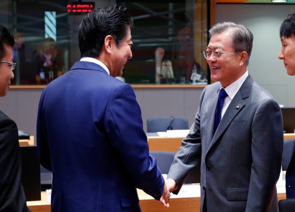 Japan's Prime Minister Shinzo Abe and South Korea's President Moon Jae-in shake hands as they attend the ASEM leaders summit in Brussels, Belgium, 19 October 2018 (Reuters/Francois Lenoir).