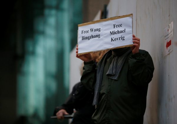 A man holds a sign calling for China to release Wang Bingzhang and former Canadian diplomat Michael Kovrig, who was arrested in China on Tuesday, at the BC Supreme Court bail hearing of Huawei CFO Meng Wanzhou in Vancouver, British Columbia, Canada, 11 December 2018 (Photo: Reuters/Lindsey Wasson).