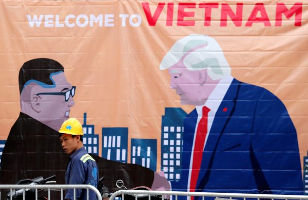 A man walks past a banner depicting North Korean leader Kim Jong-un and US President Donald Trump ahead of the North Korea-US summit in Hanoi, Vietnam, 25 February 2019 (Photo: Reuters/Kim Kyung-Hoon).