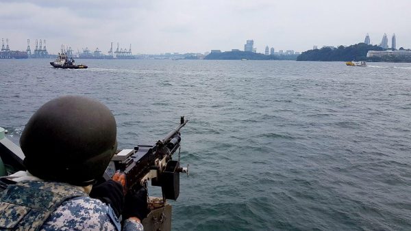 A member of Singapore's navy keeps watch as navy ships patrol the waters around Sentosa Island during a summit between US President Donald Trump and North Korean leader Kim Jong-un in Singapore, 12 June 2018 (Photo: Reuters/Singapore Ministry of Defence).