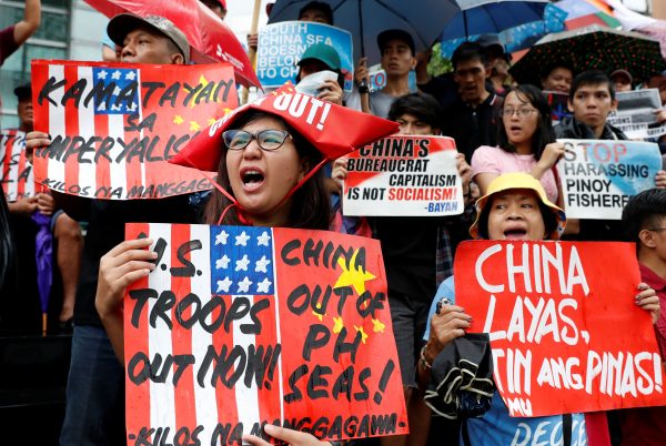 Activists display placards as they chant slogans during a rally to protest alleged harassment of Philippine fishermen at the Scarborough Shoal in the disputed South China Sea, Makati, Metro Manila, Philippines, 12 June 2018 (Photo: Reuters/Erik De Castro).