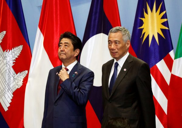 Japan's Prime Minister Shinzo Abe takes his position next to Singapore's Prime Minister Lee Hsien Loong for a group photo with ASEAN leaders at the ASEAN–Japan Summit in Singapore, 14 November 2018 (Photo: Reuters/Edgar Su).