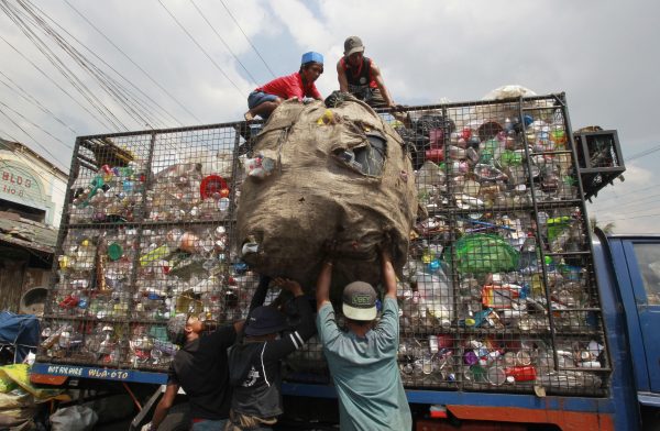 Workers load collected plastic bottles on to a truck at a junk shop in Manila, 10 March 2015 (Photo: Reuters/Romeo Ranoco).