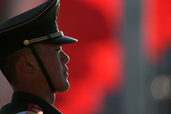A paramilitary police officer stands guard outside the Great Hall of the People before the closing session of the National People's Congress in Beijing, China, 15 March 2019 (Photo: Reuters/Jason Lee).