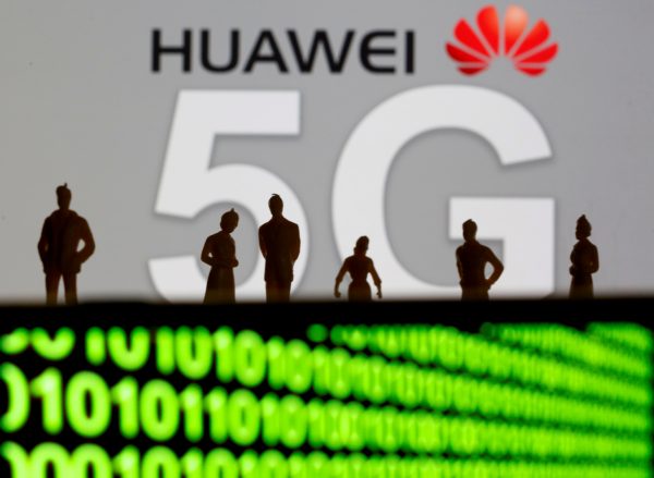 Small toy figures are seen in front of a displayed Huawei and 5G network logo 30 March 2019 (Photo: Reuters/Dado Ruvic).