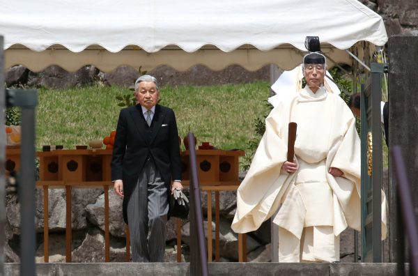 Japan's Emperor Akihito is led by a Shinto priest after visiting the tomb of his late father Hirohito to report his abdication at the Musashino Imperial Mausoleum in Tokyo, Japan 23 April 2019, (Photo: Koji Sasahara/Pool via Reuters).