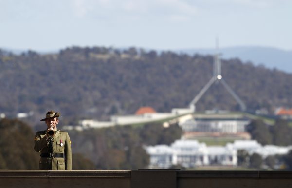 An Australian Army bugler at the Australian War Memorial plays the Last Post as he stands in front of Australia's Parliament House in Canberra, Australia, 11 September 2012 (Photo: Reuters/Tim Wimborne).