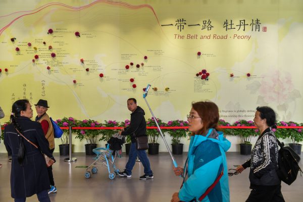 Visitors walk past a wall with a map showing the species of peony in Belt and Road Initiative (BRI) countries, at horticultural exhibition Beijing Expo 2019. Picture taken 29 April 2019. (Photo: REUTERS/Stringer)