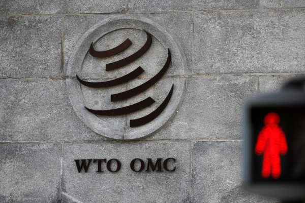 A logo is pictured outside the World Trade Organization (WTO) headquarters next to a red traffic light in Geneva, Switzerland, 2 October 2018 (Photo: Reuters/Denis Balibouse).