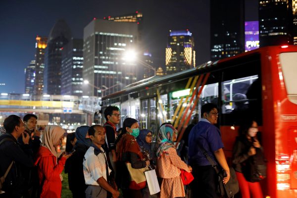 People wait for a public bus in a business district in Jakarta, Indonesia, 13 November 2018 (Photo: Reuters/Beawiharta)