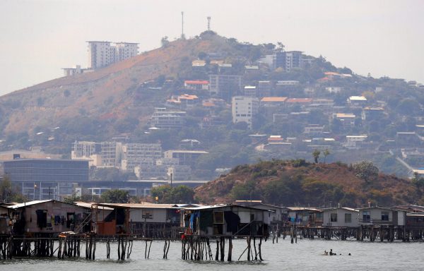 Newly constructed apartment blocks are seen behind the stilt house village called Hanuabada, located in Port Moresby Harbour, Papua New Guinea, 19 November 2018. (Photo: Reuters/David Gray).
