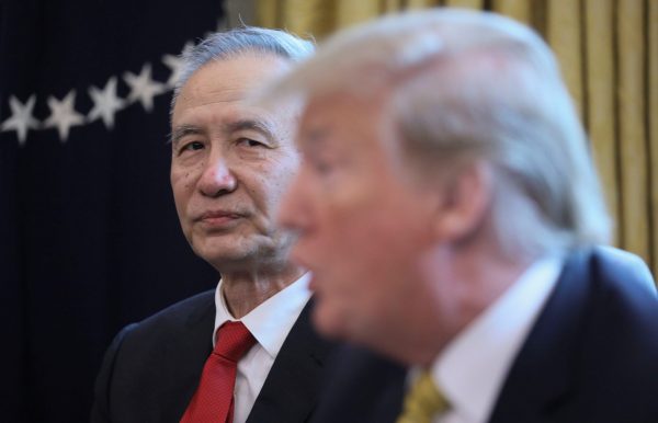 China's Vice Premier Liu He listens to US President Trump, 4 April 2019 (Photo: Reuters/Jonathan Ernst).