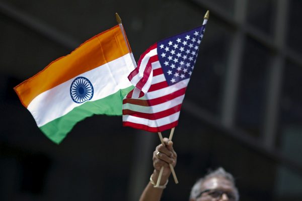 A man holds flags of India and the U.S. while people take part in the 35th India Day Parade in New York, U.S. 16 August 16 2015. (Photo: Reuters/Eduardo Munoz).