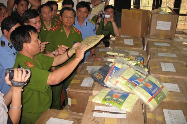 An investigator shows seized hashish to Vietnam's then deputy minister of Public Security Le The Tiem (centre) at a police station in Hanoi, Vietnam, 14 May 2008 (Photo: Reuters/Tuoi Tre Newspaper).