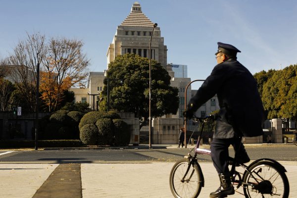 A police officer cycles past the Diet building, the seat of Japan's parliament, in Tokyo (Photo: Reuters/Thomas Peter).