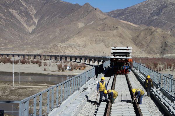 Workers fixing railway tracks on a bridge over the Yarlung Tsangpo river as part of the construction of the railway linking Lhasa and Nyingchi, Tibet (Photo: Reuters).